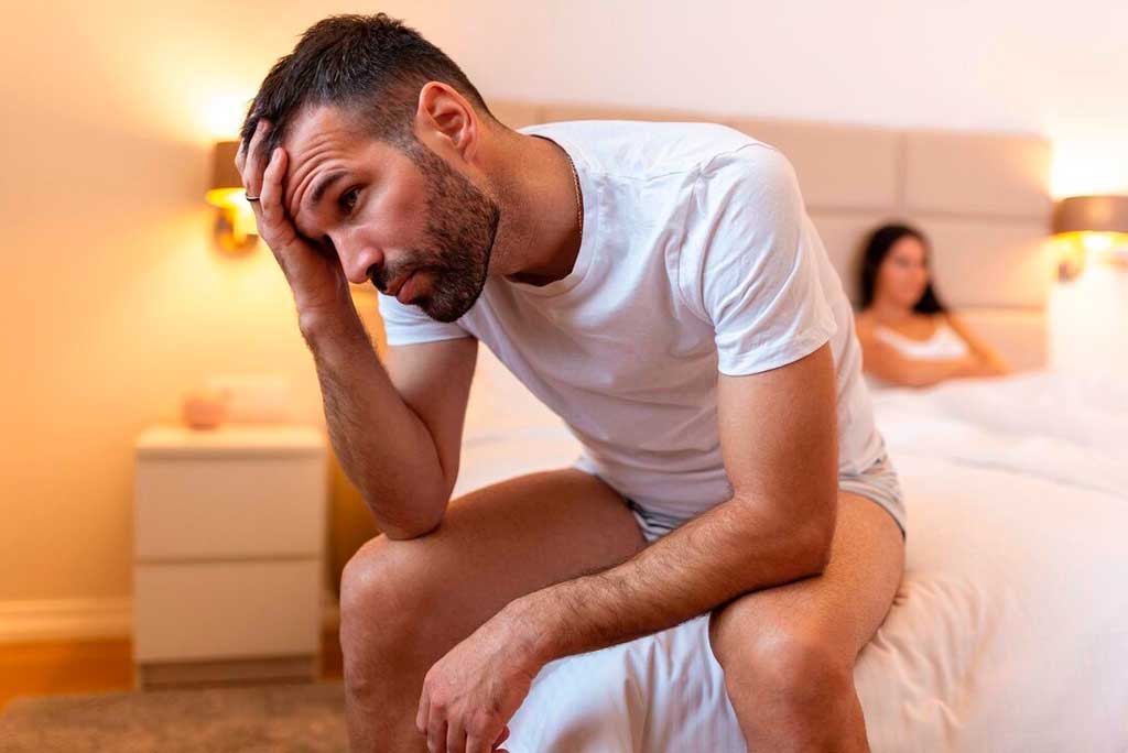 Hombre preocupado en la cama con su pareja